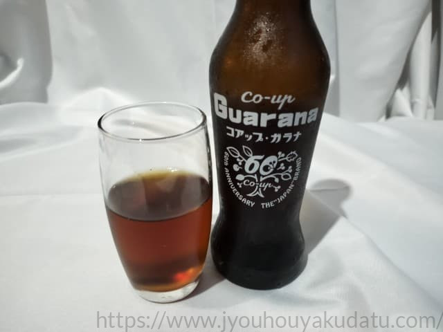 グラスに注がれたコアップガラナ。コーラのような濃い色合いをしている。