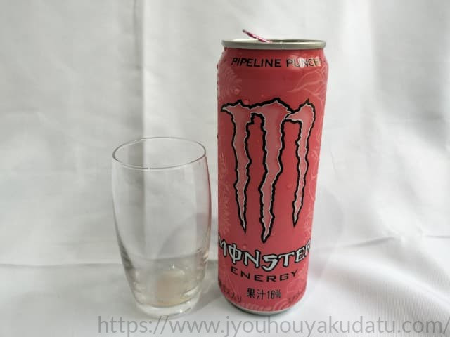 飲み終わった空の透明なグラス、底部にわずかにピンク色の液体が残っている