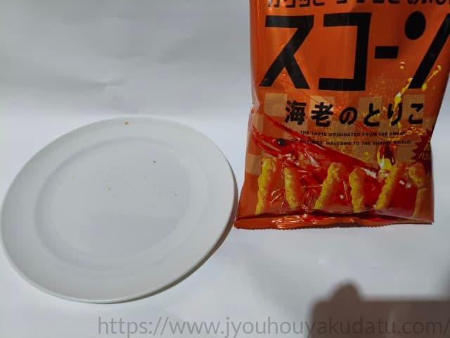 空になった白い皿と、その横に置かれた「スコーン 海老のとりこ」の空パッケージ。