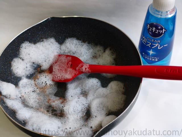 汚れたフライパンにキュキュット泡スプレーを吹きかけた様子。フライパンが大きいため全体に泡が行き渡っていない