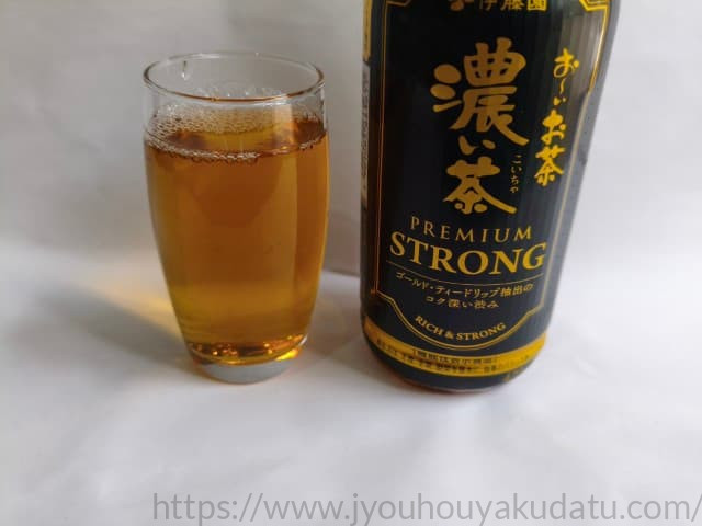 透明なグラスに注がれた、濃い緑色のおーいお茶 濃い茶 プレミアムストロング。