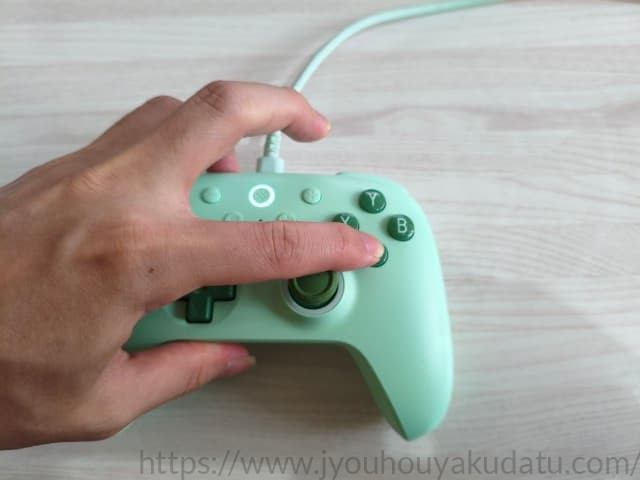 コントローラーのボタンを指で押して感触を確かめている様子