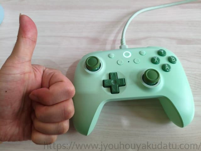 8BitDo Ultimate 2Cコントローラーの横で親指を立ててグッドポーズをしている様子