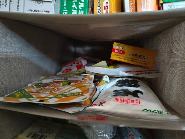 ニトリ「吊り収納 5段」の奥がふさがっていることが分かるアップ写真。棚にはカレールー、味の素（調味料）、パン粉などの食品ストックが収納されている。