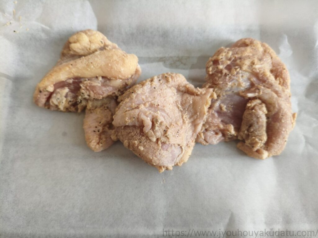 クッキングシートに載せた加熱前の唐揚げ
