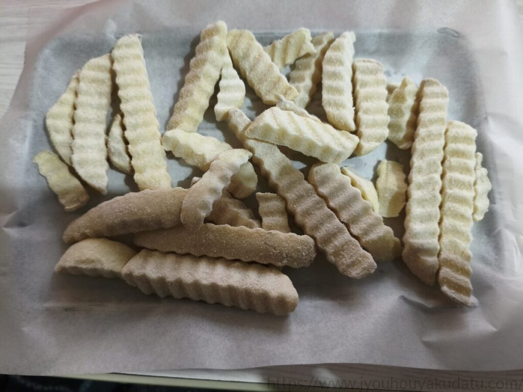 クッキングシートに載せた冷凍フライドポテト