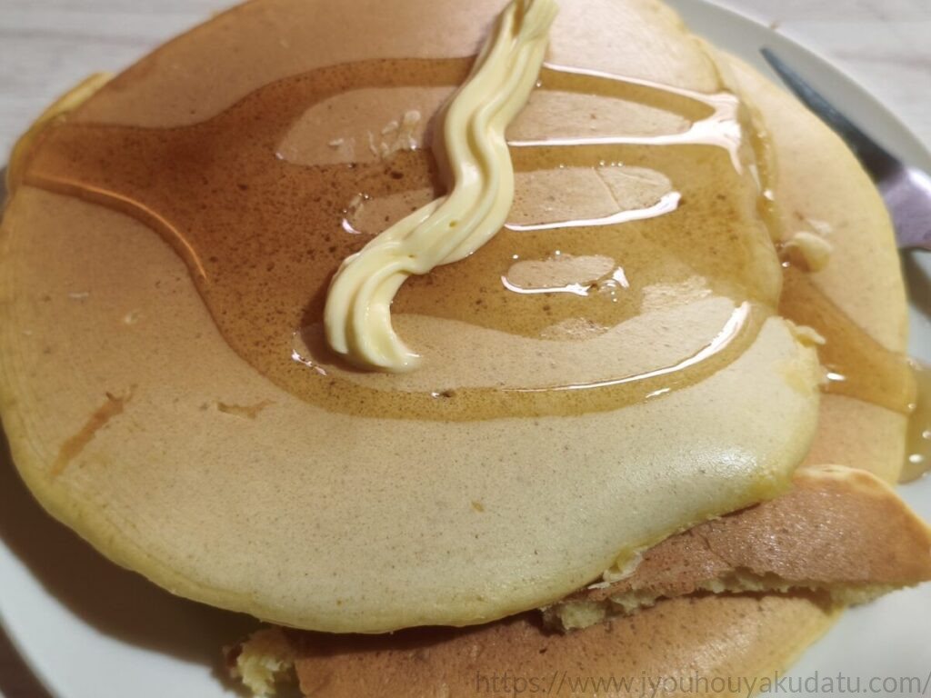 バターをのせたホットケーキにはちみつをかけている様子