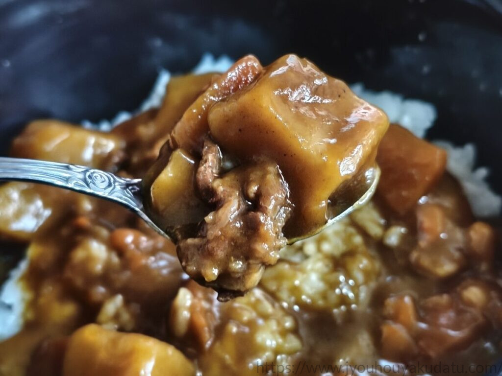 スプーンですくったボンカレーネオの大きなじゃがいもとニンジン
