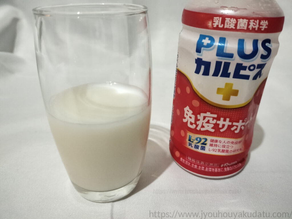 透明なグラスに注がれるプラスカルピス免疫サポート。普通のカルピスより少し色が濃い牛乳のような白色。