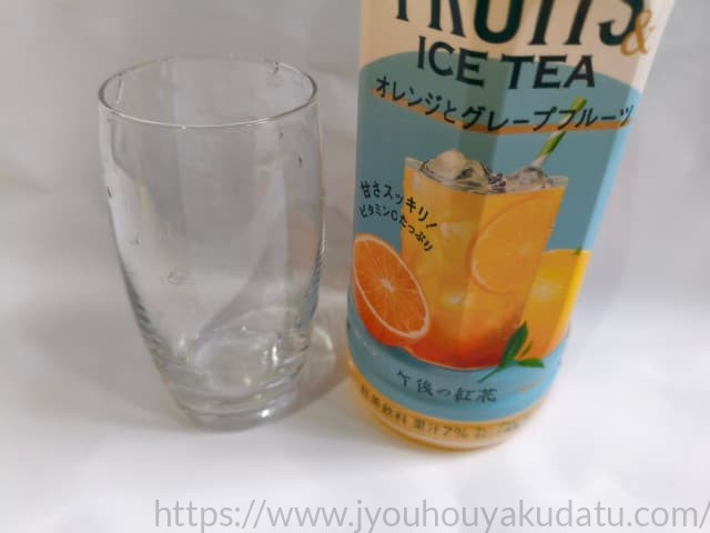 水滴が少し残った空のグラスと、その横に「午後の紅茶 フルーツ＆アイスティー」のパッケージ。