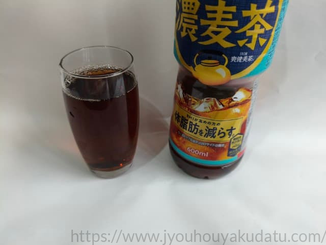 透明なグラスに注がれた「やかんの濃麦茶」。深みのある琥珀色で、光に透けている。