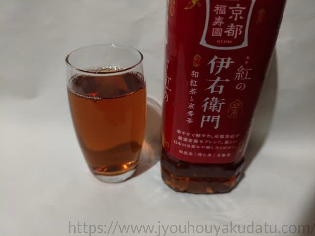 透明なグラスに注がれた、透き通った明るい茶色の「紅の伊右衛門」。