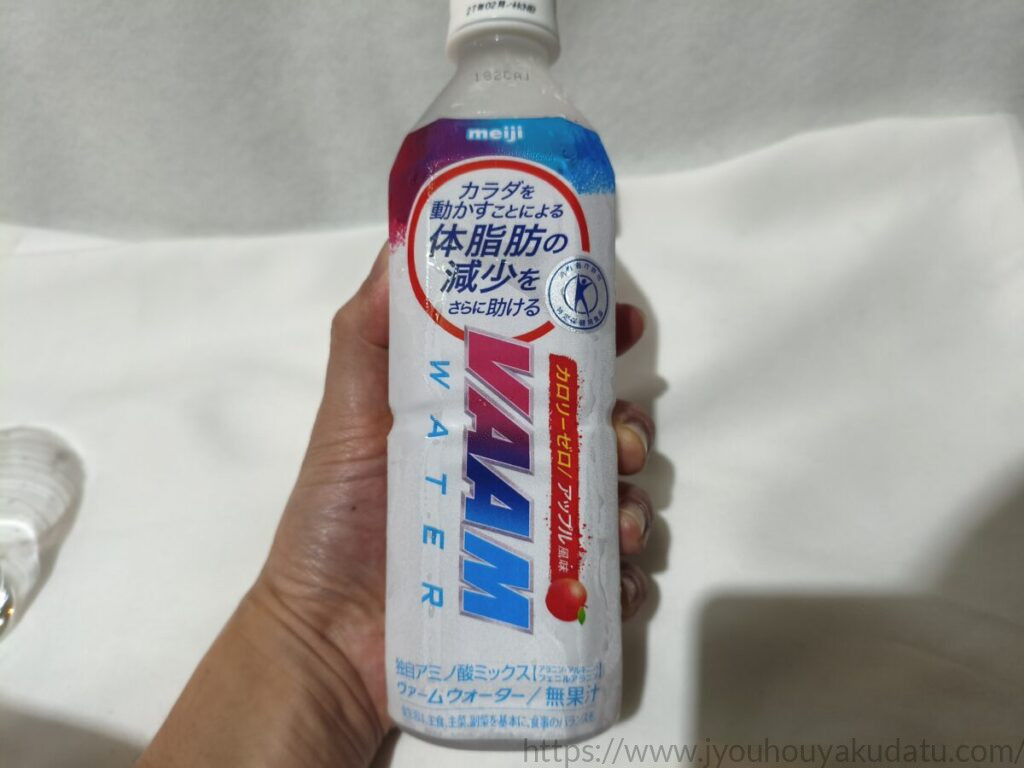 男性がヴァームウォーター アップル風味のペットボトルを手に持っている様子。500mlのサイズ感がわかる。