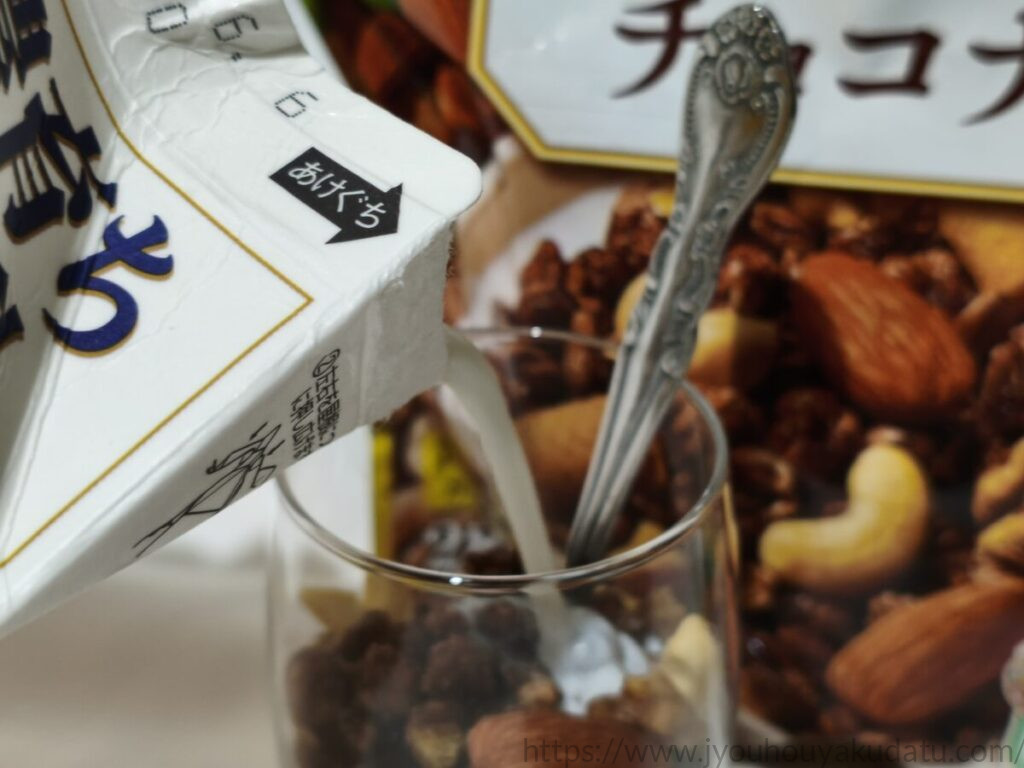 グラスに入った「ごろグラ チョコナッツ」に白い牛乳を注いでいる様子。