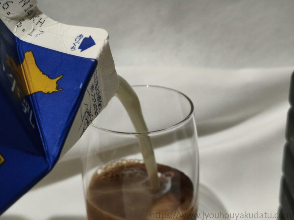 グラスのコーヒー原液に牛乳を1対1の割合で注いでいる瞬間