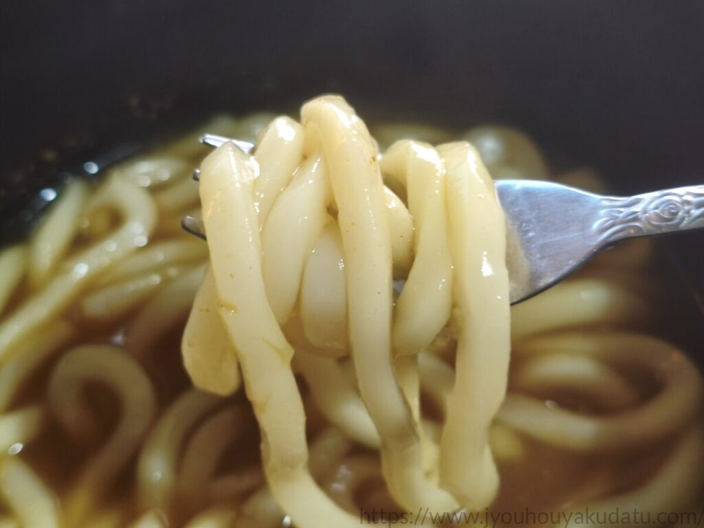 タカモリ「お蕎麦屋さんのカレーうどん」の太めの麺をフォークで持ち上げたところ