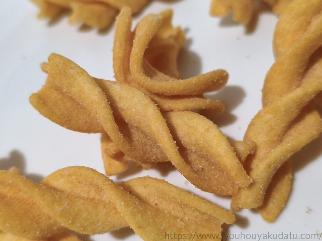 ツイスター 焼きもろこし味をアップで撮影した様子。スナック表面に味付けの粉が付いている