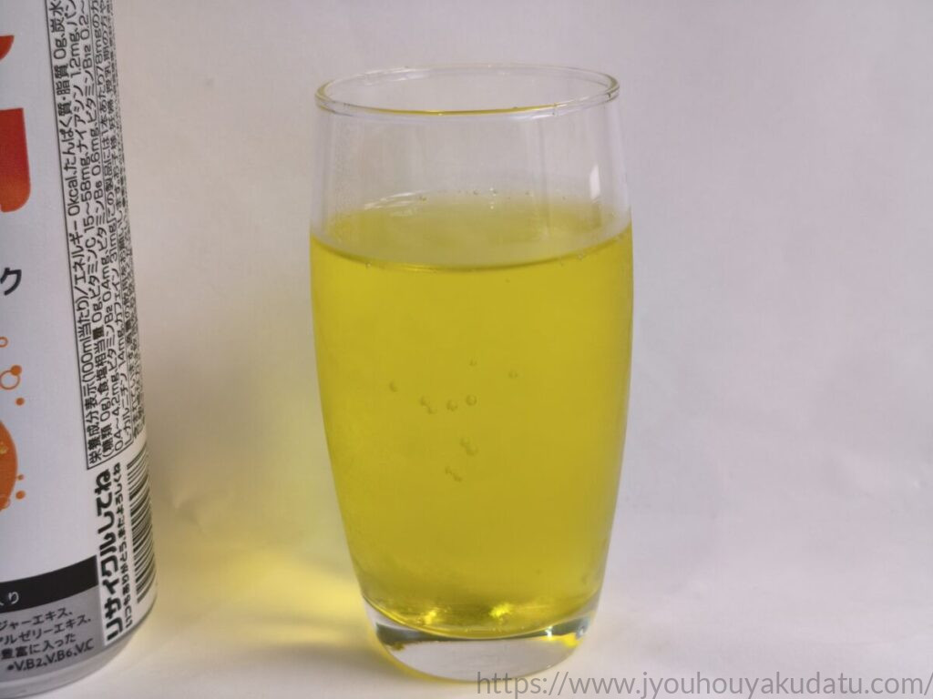 グラスに注いだリアルゴールド RG オレンジ。レモン色の液体に炭酸の泡が見える