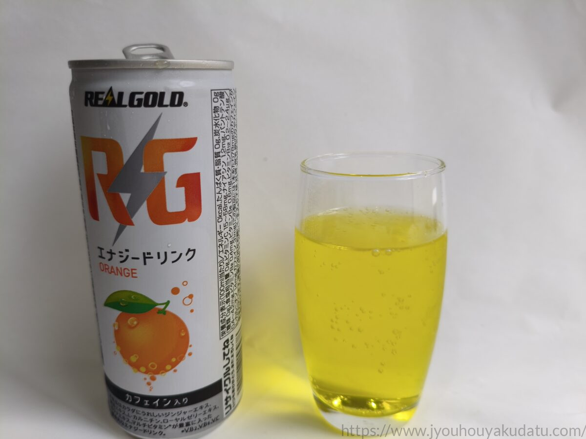リアルゴールド RG オレンジの缶と、黄色い炭酸飲料を注いだグラス