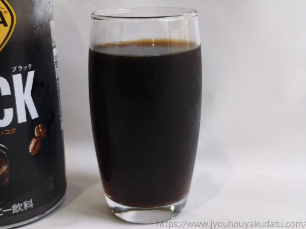 透明なグラスに注がれたジョージア ブラックのコーヒー。濃い茶色の液色が分かるアップ写真